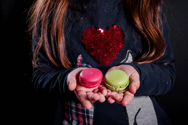 Macaroons in the palms of the girl