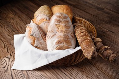 ekmek ve baget ahşap bir masa üzerinde bir hasır sepet içinde çeşitli