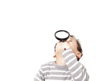 Küçük çocuk büyüteçle bakıyor.