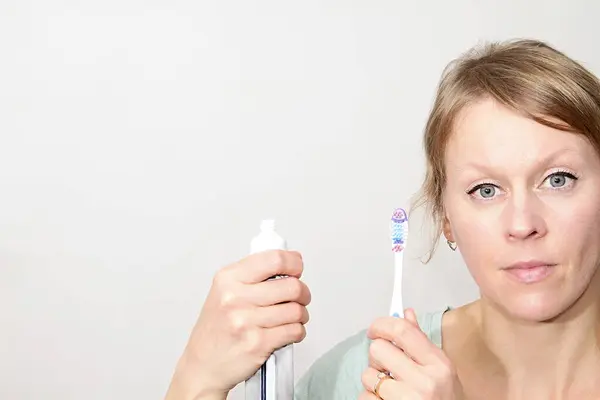 Woman brushing her teeth with tooth brush