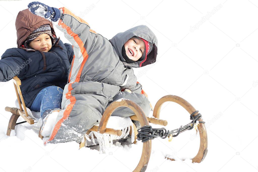 children on sledge in the snow having a great time