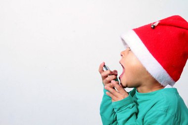 Cep telefonu olan küçük çocuk Noel Baba 'yı arıyor. 