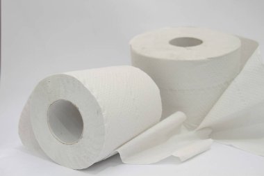 Masada beyaz arka planı olan tuvalet kağıdı rulosu var.