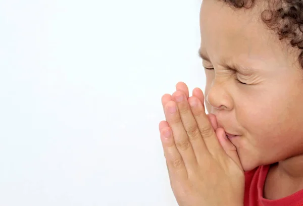 boy praying to God with hands held together stock photo
