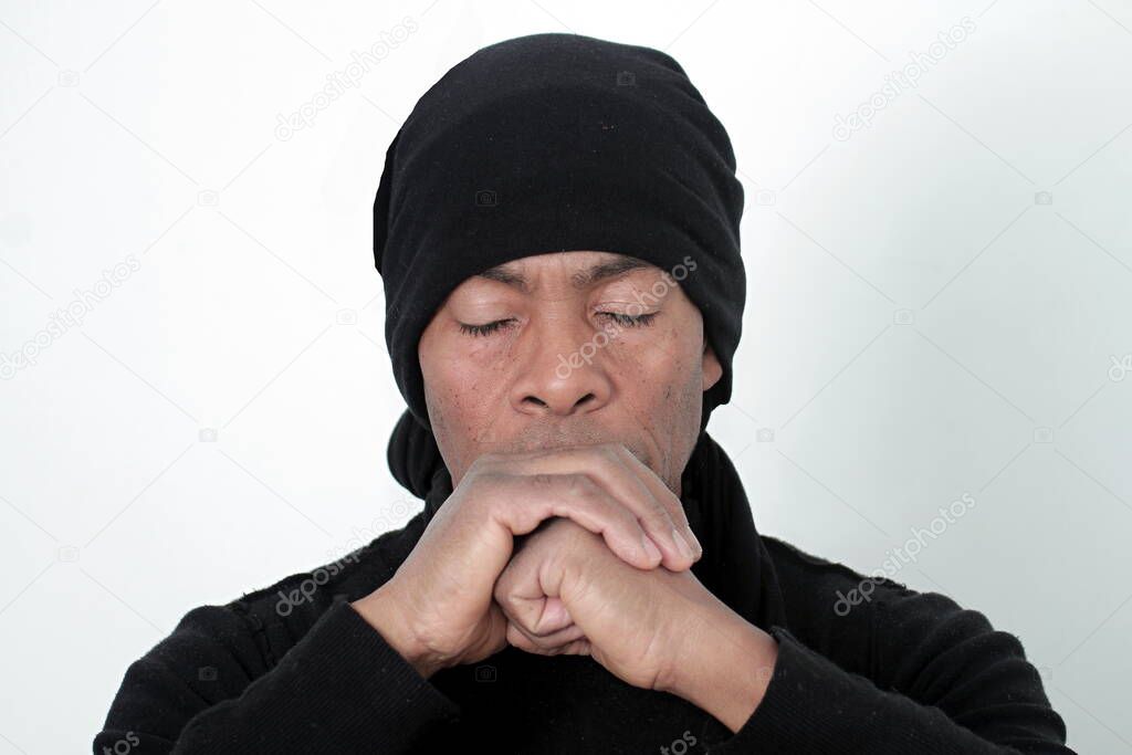 man praying to god with hands together Caribbean man praying with white background stock photo