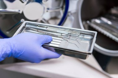 Doktor klinikteki özel ekipmanları sterilize eder.