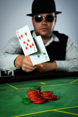 Bir poker oyuncusu kötü bir kart atar.
