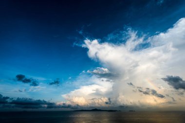 Tayland 'da gün doğumu. Bulutlar ve okyanusun üzerinde bir gökkuşağı