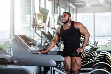 Spor salonunda koşu bandında genç bir sporcu.