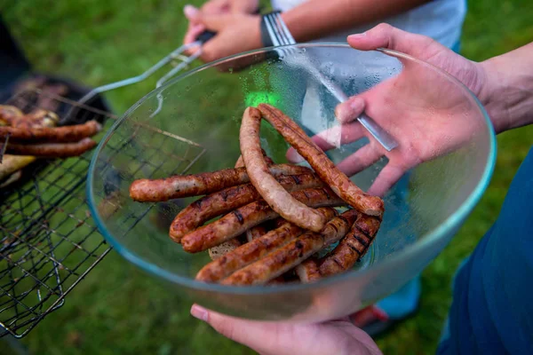 Natural homemade sausages grilled. A man holding a plate