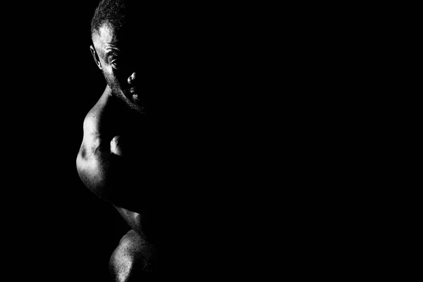 Male athlete in the shade on a black background — Stock Photo, Image