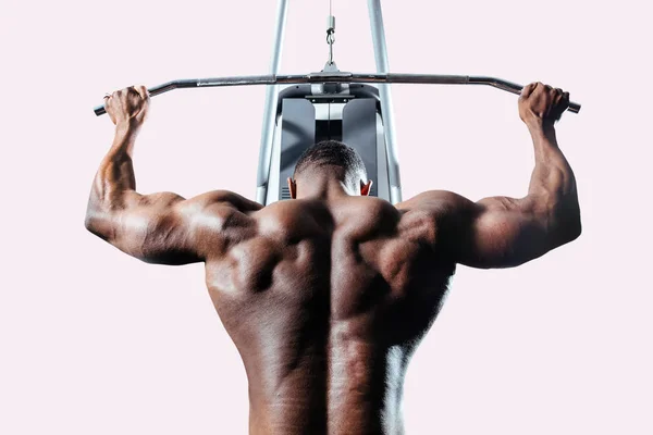 Спортсмен тягне блок в тренажер для розвитку м'язів спини — стокове фото