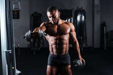Atlet spor salonunda elinde dumbbells ile