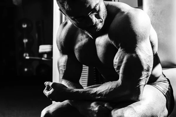 L'athlète dans la salle de gym assis sur le banc — Photo