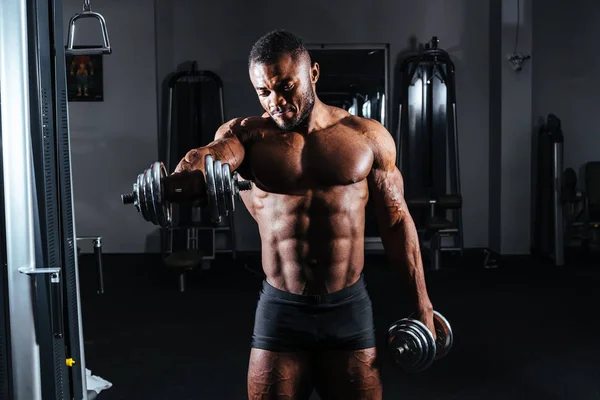 Athlète avec haltères dans les mains dans la salle de gym — Photo