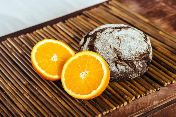 Апельсин нарезан и хлеб на столе — стоковое фото