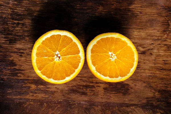 Dos mitades de una naranja sobre un fondo de madera — Foto de Stock