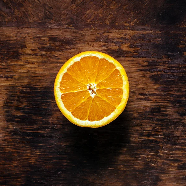 Половина апельсина на деревянном фоне — стоковое фото