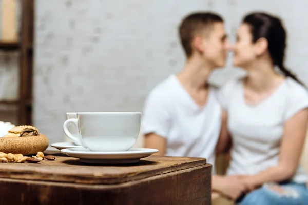 Две чашки кофе на фоне любящей пары — стоковое фото