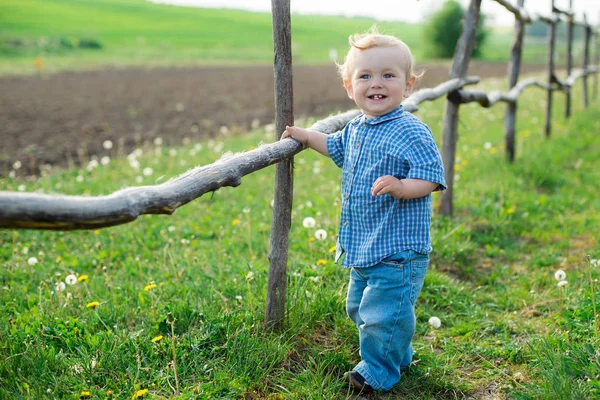 陽気な男の子がフェンスの近くに立っています。 — ストック写真