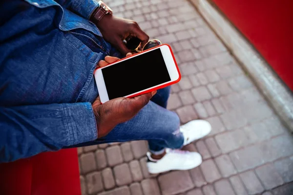 A young guy holding a mobile phone on the street — Stock Photo, Image