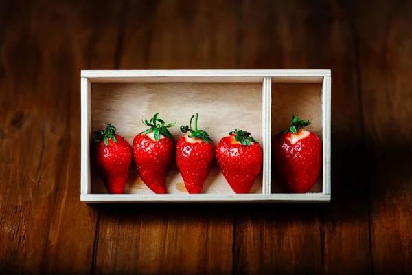 Strawberries in a wooden box on a wooden background