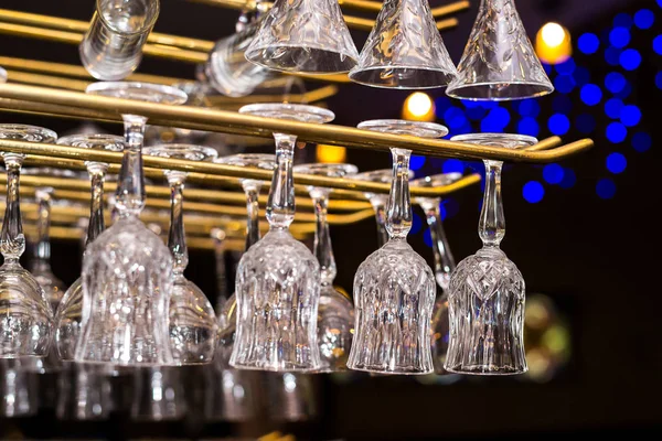 Окуляри для алкогольних напоїв висять над барною стійкою — стокове фото