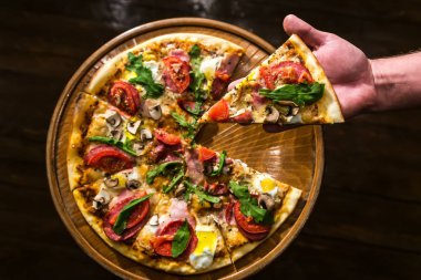 Bir parça pizza elinde