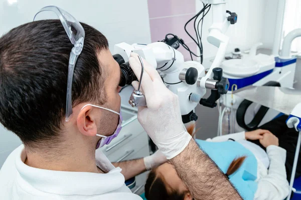 Il dentista esamina i denti del bambino con un microscopio. Attrezzature dentali professionali — Foto Stock