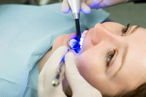 Dentista trabajando con lámpara de polimerización dental —  Fotos de Stock