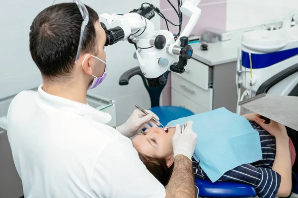 หมอฟันใช้กล้องจุลทรรศน์ — ภาพถ่ายสต็อก