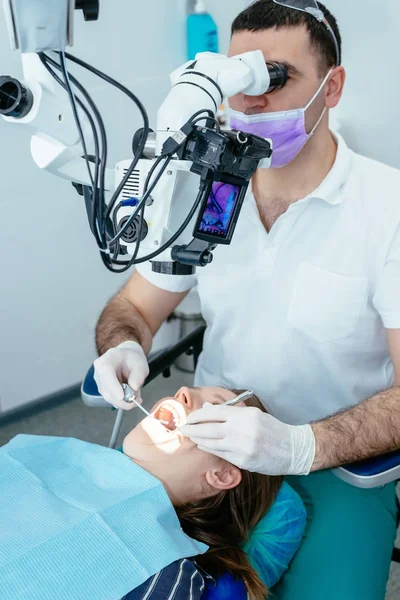 Medico dentista utilizza un microscopio — Foto Stock