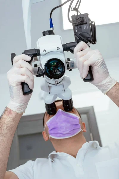 Dentiste avec un microscope dans une clinique dentaire — Photo