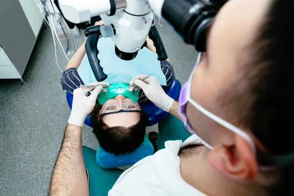 หมอฟันใช้กล้องจุลทรรศน์ฟัน — ภาพถ่ายสต็อก