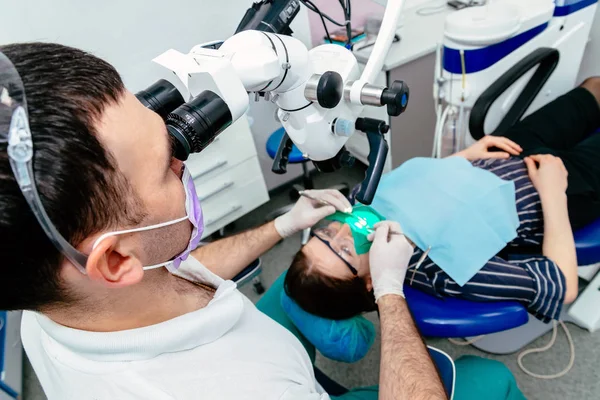 Medico dentista utilizza un microscopio — Foto Stock