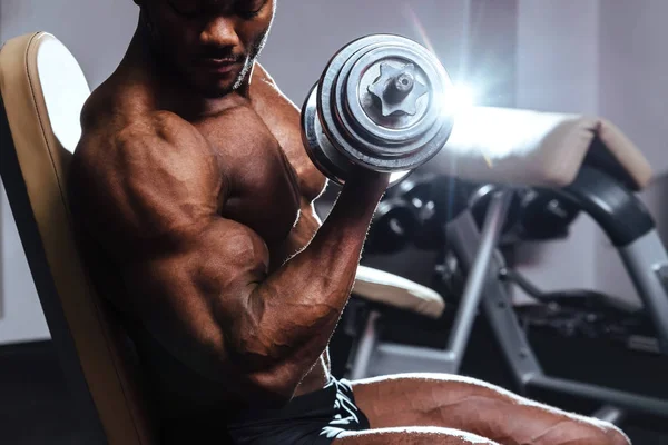 Atleta masculino levanta o bíceps haltere no ginásio — Fotografia de Stock