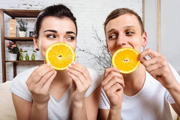 Amante casal tomando café da manhã com laranjas frescas — Fotografia de Stock