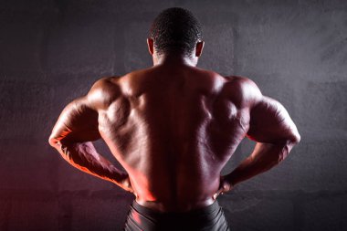 Afrika kökenli Amerikalı erkek sporcu sırt ve kollarda gelişmiş kaslar gösteriyor.