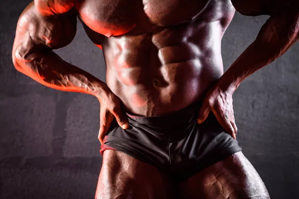 Primer plano de un culturista. Atleta masculino afroamericano posando demostrando desarrollo muscular —  Fotos de Stock