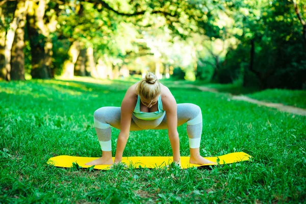 Jeune fille enceinte faisant du yoga dans le parc — Photo