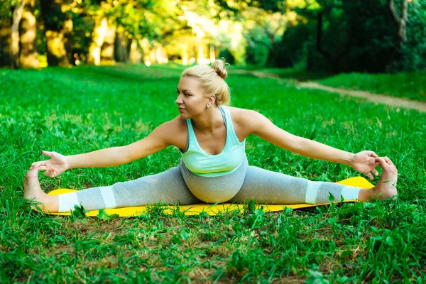 Jeune fille enceinte faisant du yoga dans le parc — Photo