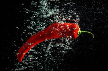 Taze kırmızı biberler kabarcıklarla suya atılır.