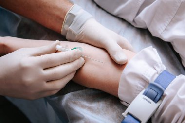 Doktor, bir hastadan analiz için damardan kan alıyor.