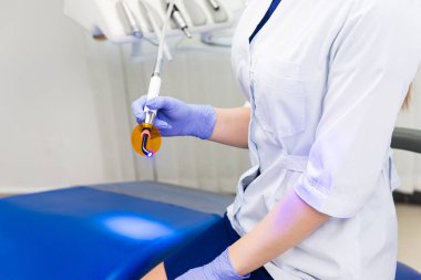 Kadın doktor hastane ofisinde dişçi malzemesi kullanıyor.