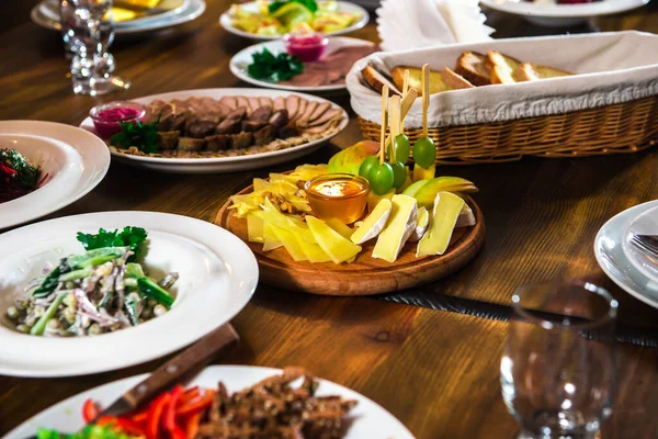 Сырная тарелка на столе с различными блюдами — стоковое фото
