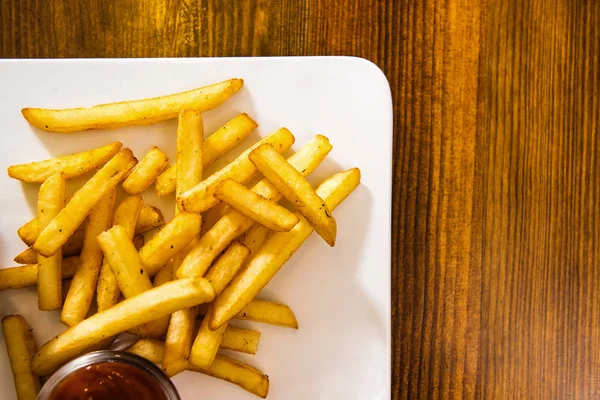 French fries on a wooden table. View from the top — Stock Photo, Image
