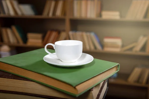 ?café fresco en una pila de libros viejos en la biblioteca — Foto de Stock