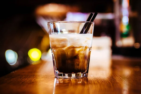 Cocktail alcoolisé avec glace dans un bar sur une table en bois — Photo