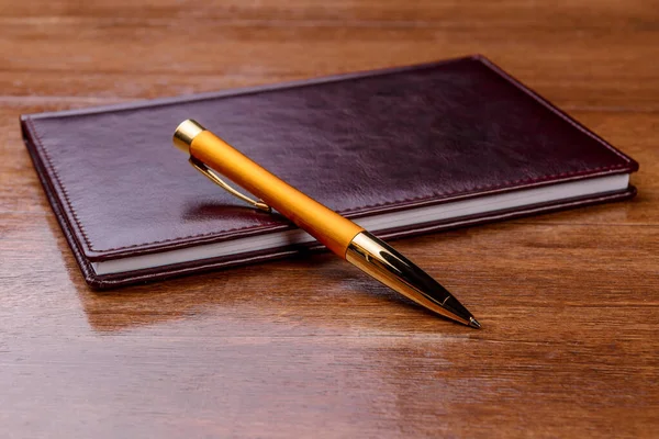 Notebook and pen on wood background — Stock Photo, Image