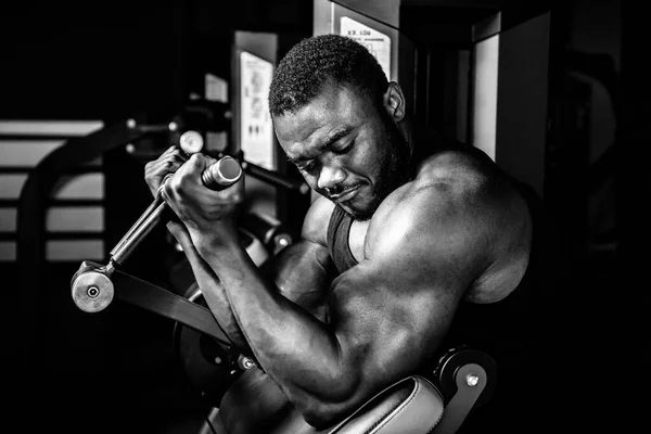 Hombre atleta, culturista, haciendo ejercicio en el gimnasio . — Foto de Stock